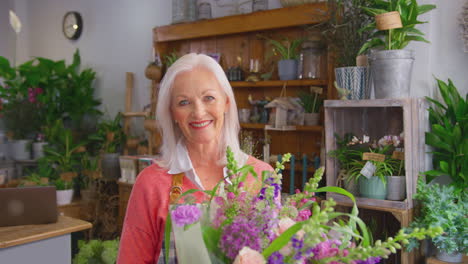 Portrait-Of-Female-Owner-Of-Florists-Shop-Holding-Bouquet-Of-Flowers