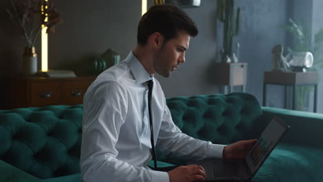 Businessman working on laptop in office. Employee looking at graphs on screen