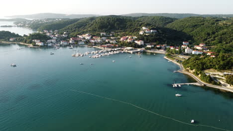 aerial view of rab island, croatia, small coastal town, harbor marina and calm adriatic sea on summer day, drone shot