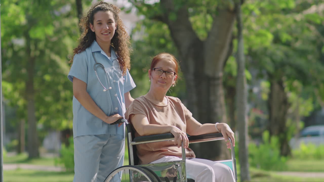 Caregiver assisting senior woman in wheelchair at the park