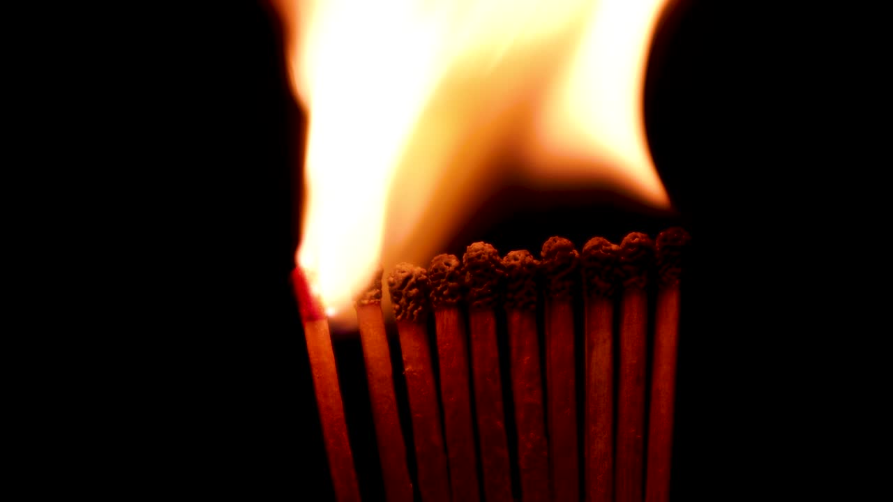 검은색 배경에서 일련의 점화 매치 스틱. 매치 스을 태우는 비디오. 사회적 거리 두기 개념 영상. 도미노 효과. 전염병의 확산을 멈추기.