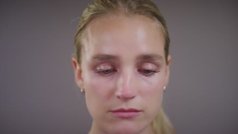 close up of emotional young blonde woman crying