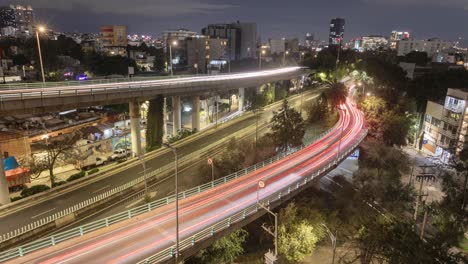 imágenes timelapse de la ciudad de méxico por la noche, mostrando los vehículos que se mueven en las calles principales de la ciudad, con el horizonte en el fondo