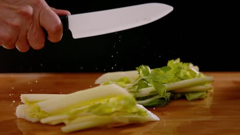 coltello da chef affilato tagliato più volte il sedano, vista ultra slow motion