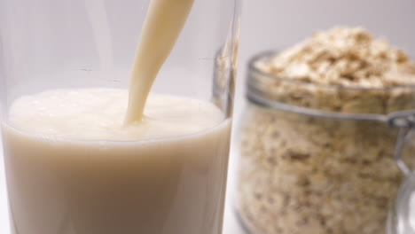 pouring vegan friendly oat milk close up slow motion