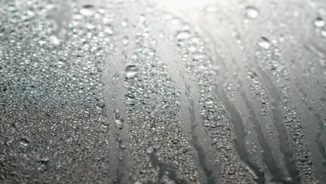 close up view of water drops falling on glass. rain running down on window. rainy season, autumn or spring. raindrops trickle down, grey sky. close up, soft focus.