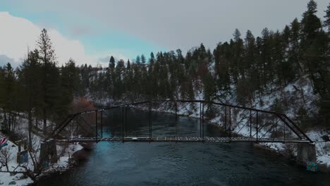 Snowy-river-in-spokane-Washington,-spokane-river-during-winter-over-abandoned-railway-bridge-right-by-doomsday-hill