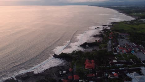 Drone-Vuela-Sobre-El-Templo-Hindú-De-Tanah-Lot-En-Bali,-Indonesia,-Isla-De-Dioses,-Tradición-Y-Ceremonia,-Vista-Del-Paisaje-Marino-Del-Océano-Durante-La-Impresionante-Puesta-De-Sol