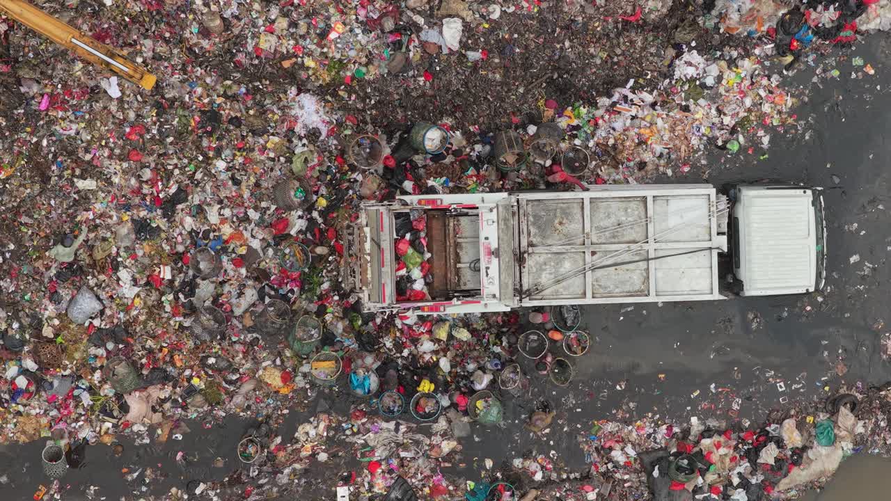 Camion della spazzatura che scarica rifiuti in una discarica inquinata.