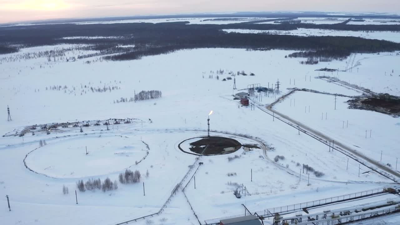 воздушный вид на газ, горящий из факельной структуры в зимнее время на нефтяных месторождениях