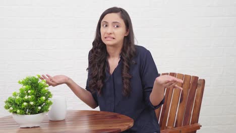 chica india confundida sentada en un café