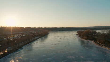 Aerial-shot-of-glassy-clear-frozen-water-at-sunset