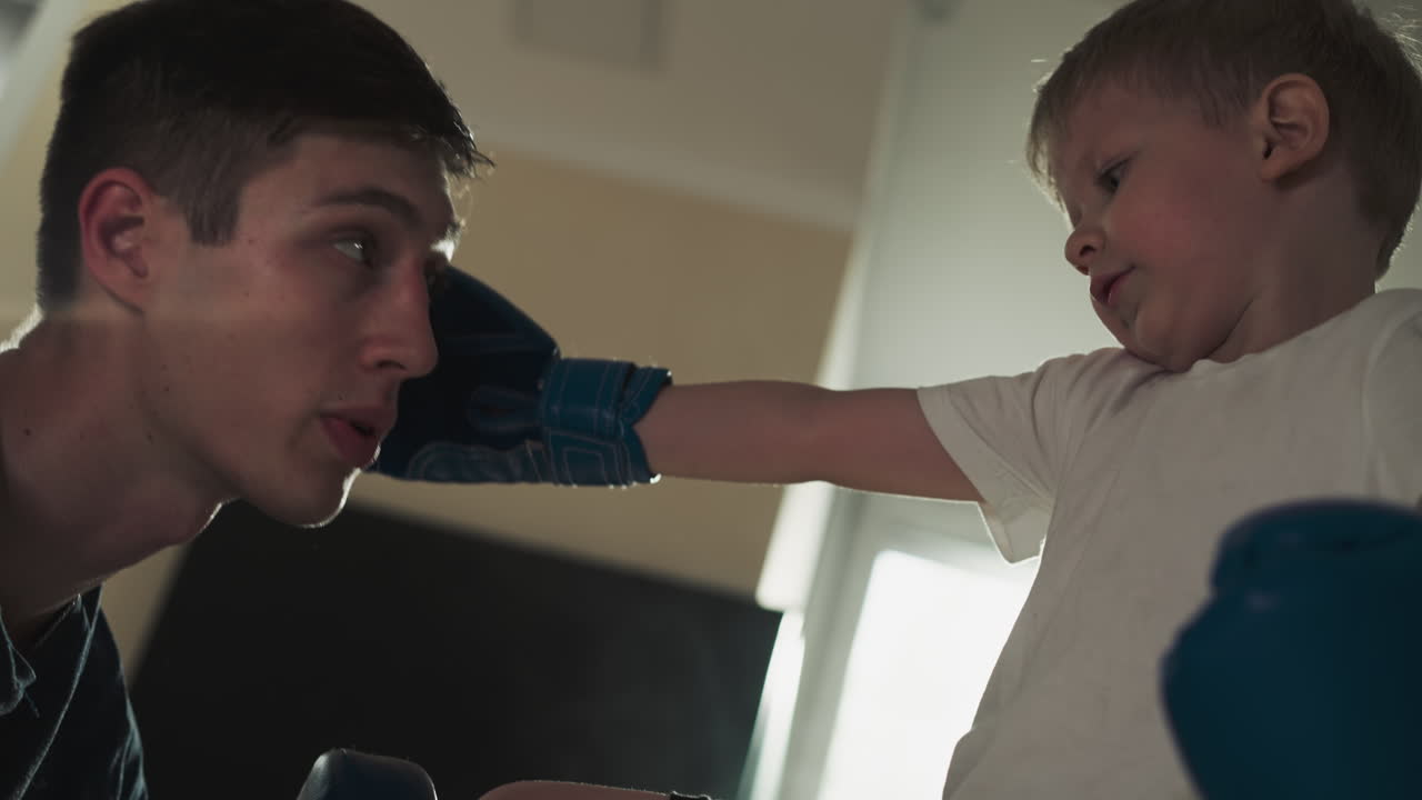 교사는 전투 체육관에서 학생과 함께 타격을 훈련시니다. 젊은 주인은 스포츠 센터에서 과 주먹을 가르니다. 느린 움직임. 강한 아이.