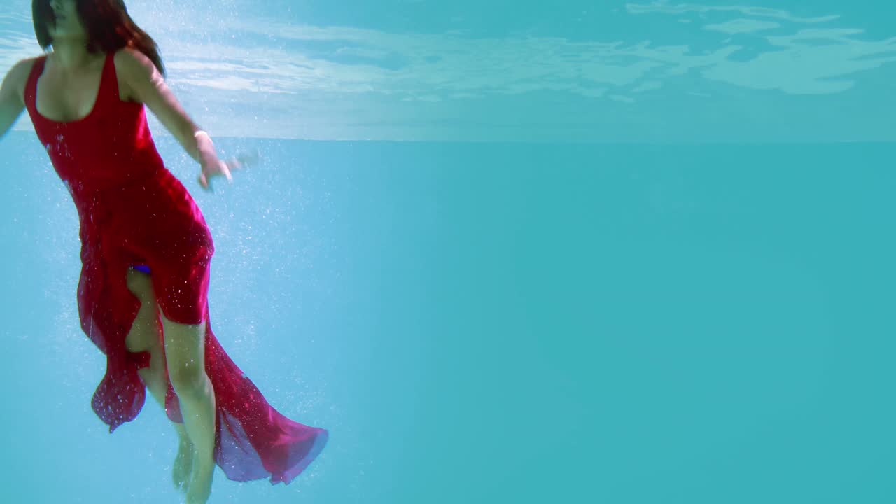 저녁 드레스 를 입은 갈색 여자 가 수영장 에 다이빙 하고 있다