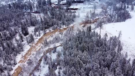 aerial shot of the natural hot springs in the winter forest canyon