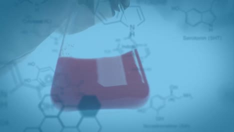 Laboratory-beaker-with-data-and-structural-formula-of-chemical-compounds-in-the-foregr