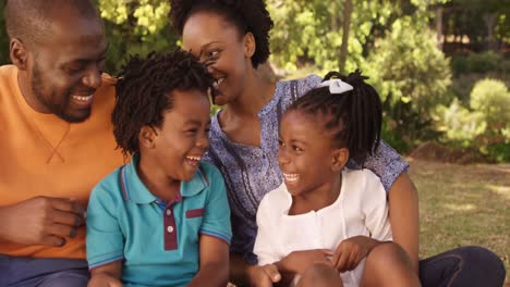 Cute-family-is-sitting-in-the-grass-and-laughing-