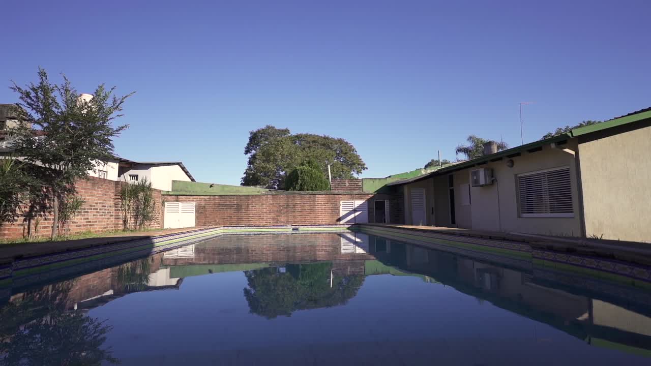 Serene outdoor scene showcases large swimming pool and lush courtyard bathed in afternoon light. Perfect for vacation rental listings.