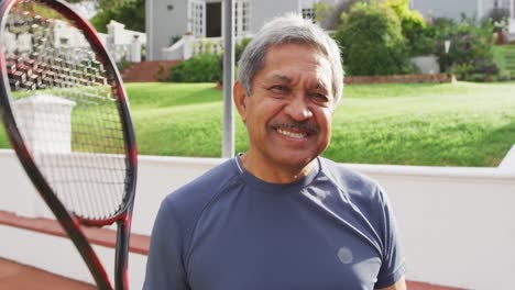 video of happy biracial senior man holding tennis racket