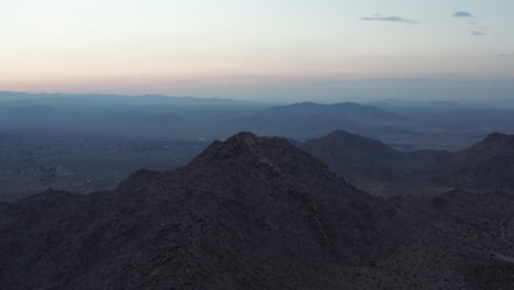 Toma-Aérea-De-Una-Montaña-Durante-La-Puesta-De-Sol-Tardía-En-Joshua-Tree-California