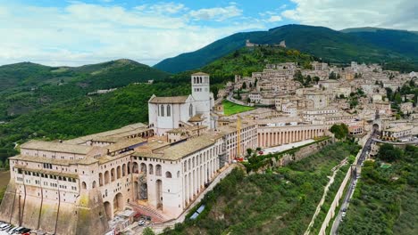 flying towards the basilica of saint francis of assisi, famous hillside catholic church in assisi, italy