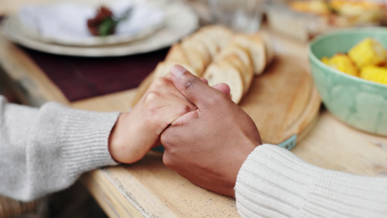 A couple holding hands at the dinner table