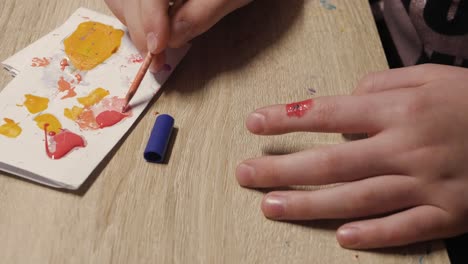 aplicando una herida de sangre falsa en el dedo índice con un arbusto de pintura, cerrado