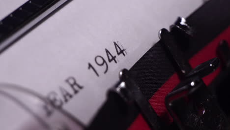 year 1944, typing on white paper in vintage typewriter, macro close up