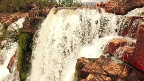 toma cinemática de drones volando bajo y rápido sobre el borde de una cascada