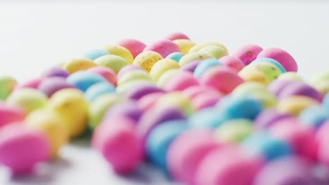 close up of multiple colorful easter eggs on white background