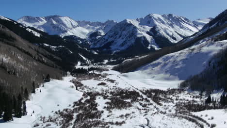 Oben-An-Einem-Sonnigen-Frühlingstag,-Winter,-Colorado,-Wunderschöne-Aussicht-Auf-Die-Berge-Und-Friedlicher-Bach,-Ashcroft,-Kastanienbraune-Glocken,-Aspen,-Colorado,-Ikonische-Landschaft,-Luftaufnahme-Nach-Vorne,-Schwenk-Offenbaren-Bewegung