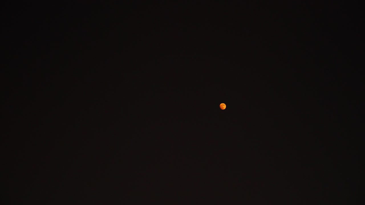red moon floating on skyline of seoul at nighttime