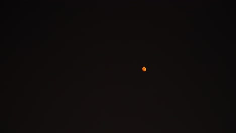 red moon floating on skyline of seoul at nighttime