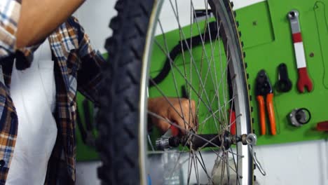 mechanic repairing bicycle in workshop