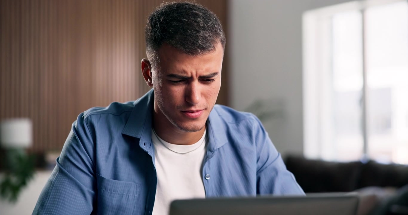 Stressed Young Man Working on Laptop at Home