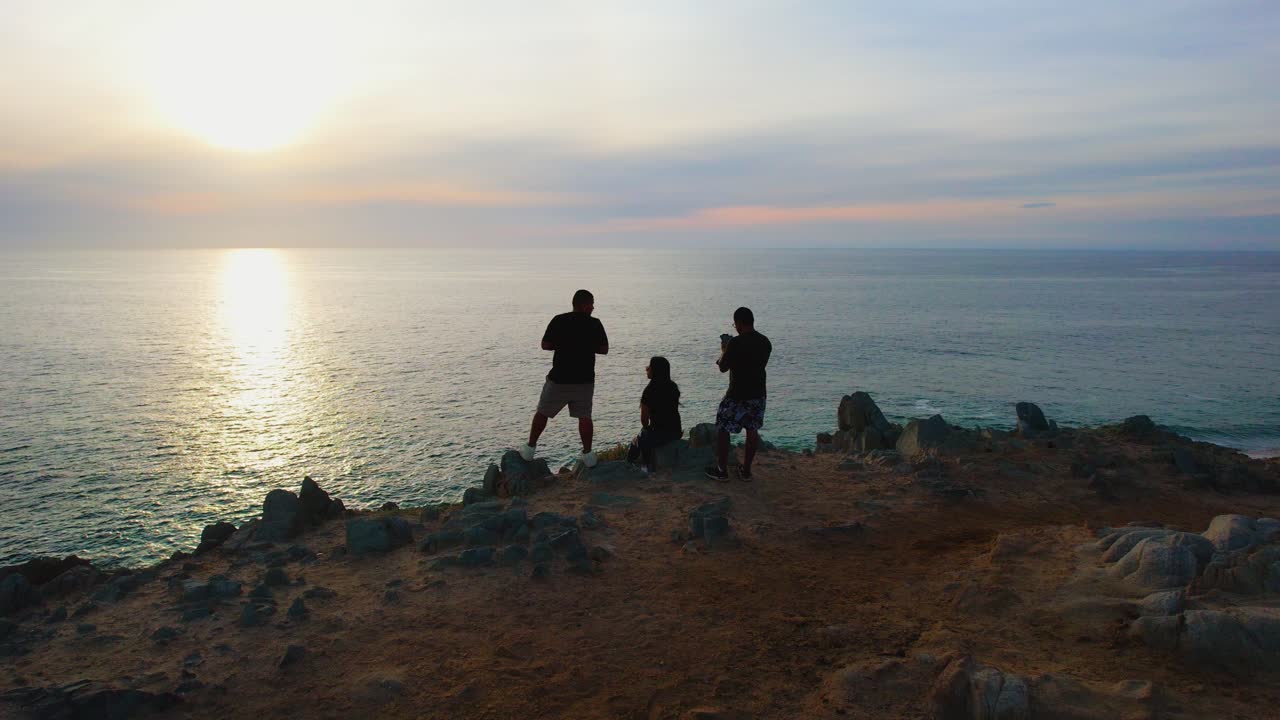 해변 절벽에서 드론을 날리는 사람들의 공중 전망, 멕시코 카보 산 루카스의 일몰