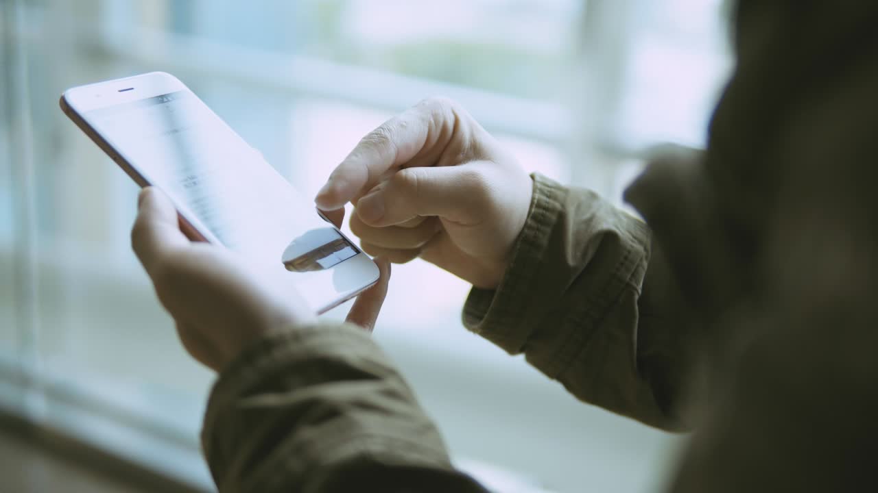 uomo che usa lo smartphone in una stazione della metropolitana