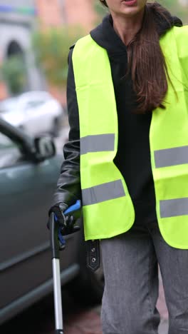 young woman cleaning up litter on city street