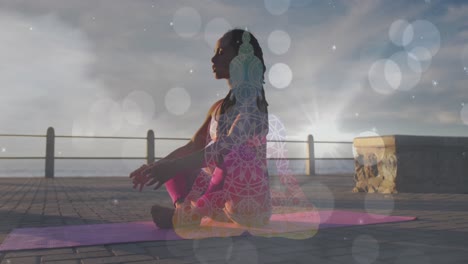 white spots of light falling against african american fit woman performing yoga on the promenade