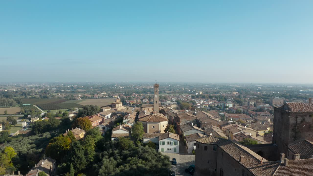 Ripresa aerea con drone della torre dell'orologio, dei tetti e della campagna circostante di Santarcangelo di Romagna in una giornata limpida