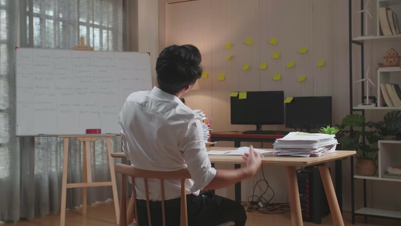 문서 를 열심히 작업 하는 동안 의자 에 기대어 잠을 자고 있는 아시아인 의 뒷면