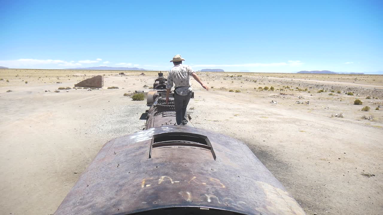 imágenes de un turista saltando sobre los trenes en el cementerio de trenes en bolivia