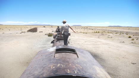 Aufnahmen-Eines-Touristen,-Der-Auf-Dem-Friedhof-Der-Züge-In-Bolivien-über-Die-Züge-Springt