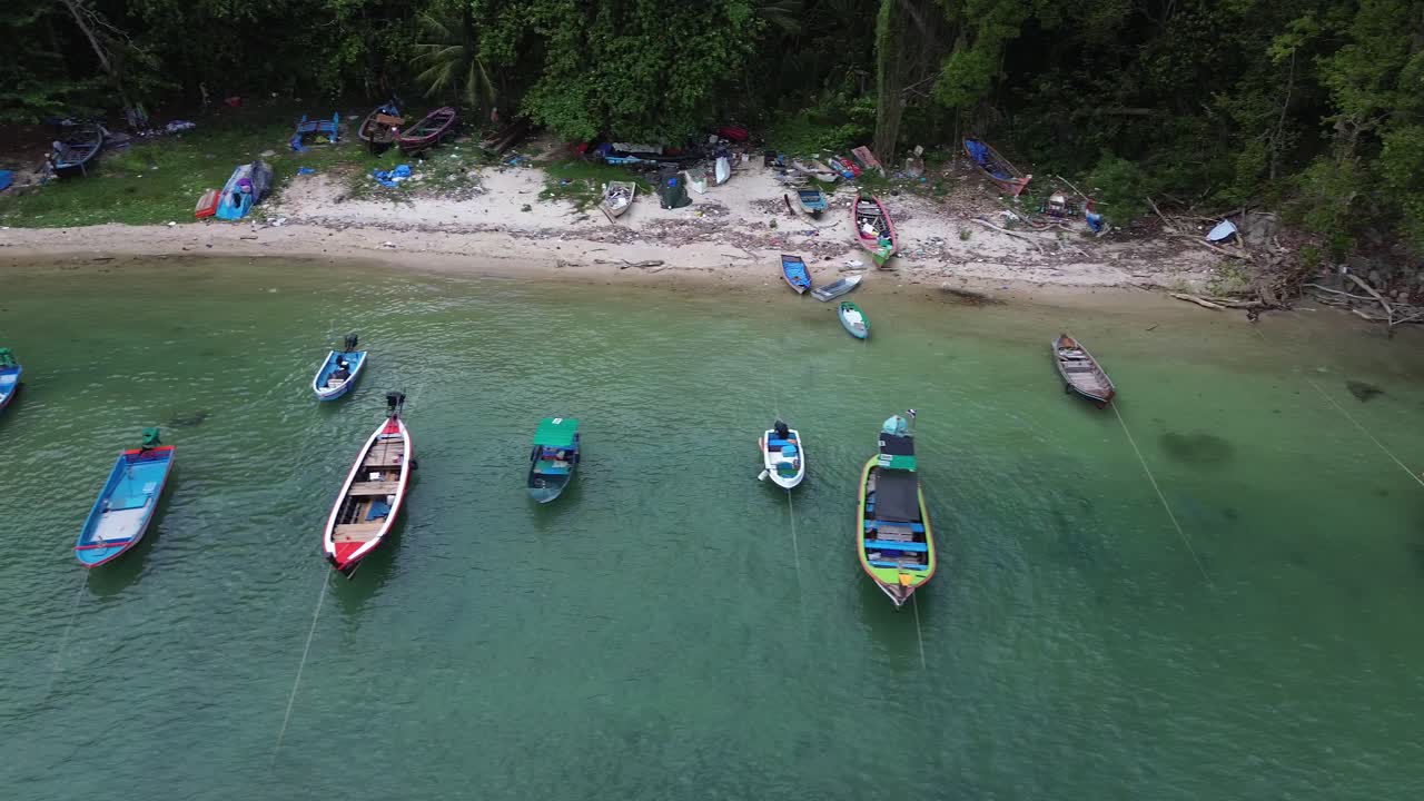 Vista dall'alto con drone di tradizionali barche a coda lunga che galleggiano su acque limpide color turchese accanto a una piccola spiaggia sabbiosa a Patong, Phuket, Thailandia. Destinazione di viaggio tropicale
