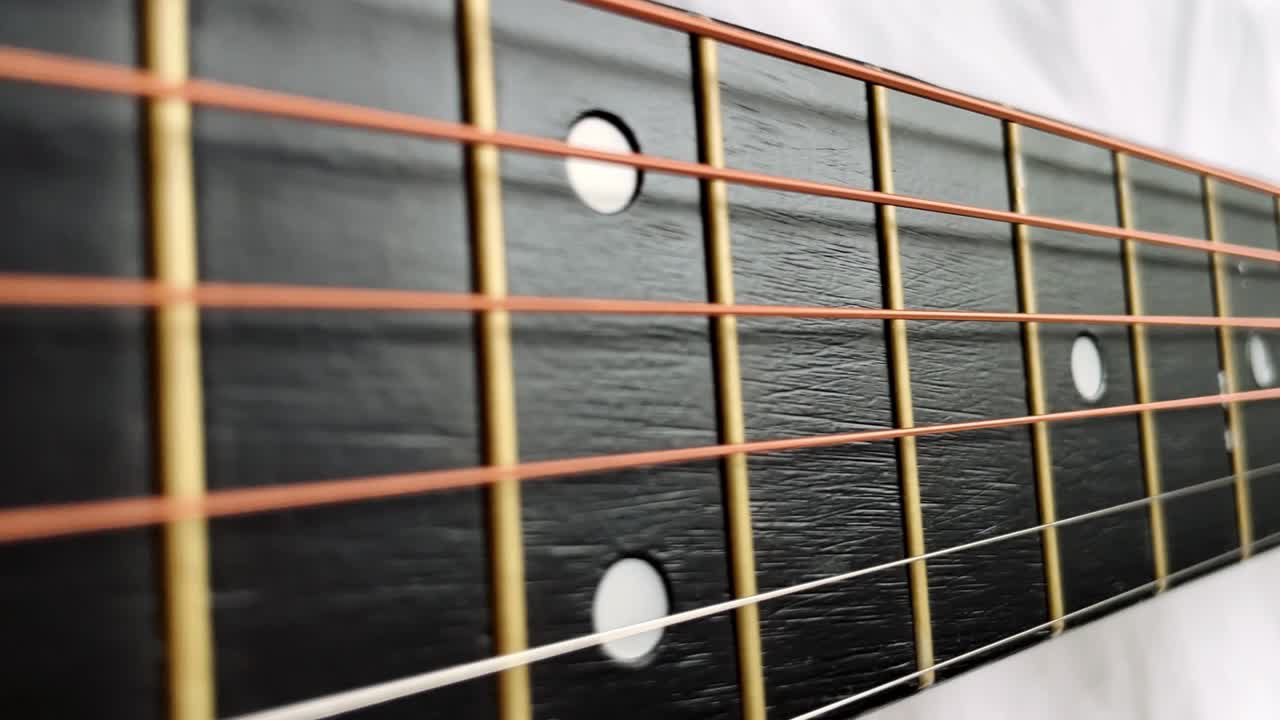 Zoom in shot of black frets fretboard acoustic guitar string