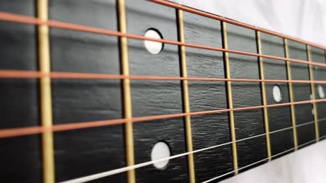 zoom in shot of black frets fretboard acoustic guitar string