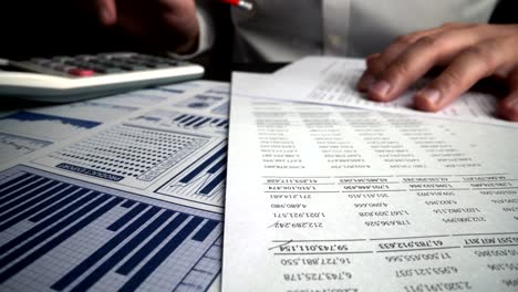 accountant analyzing business marketing data on paper dashboard at office table.