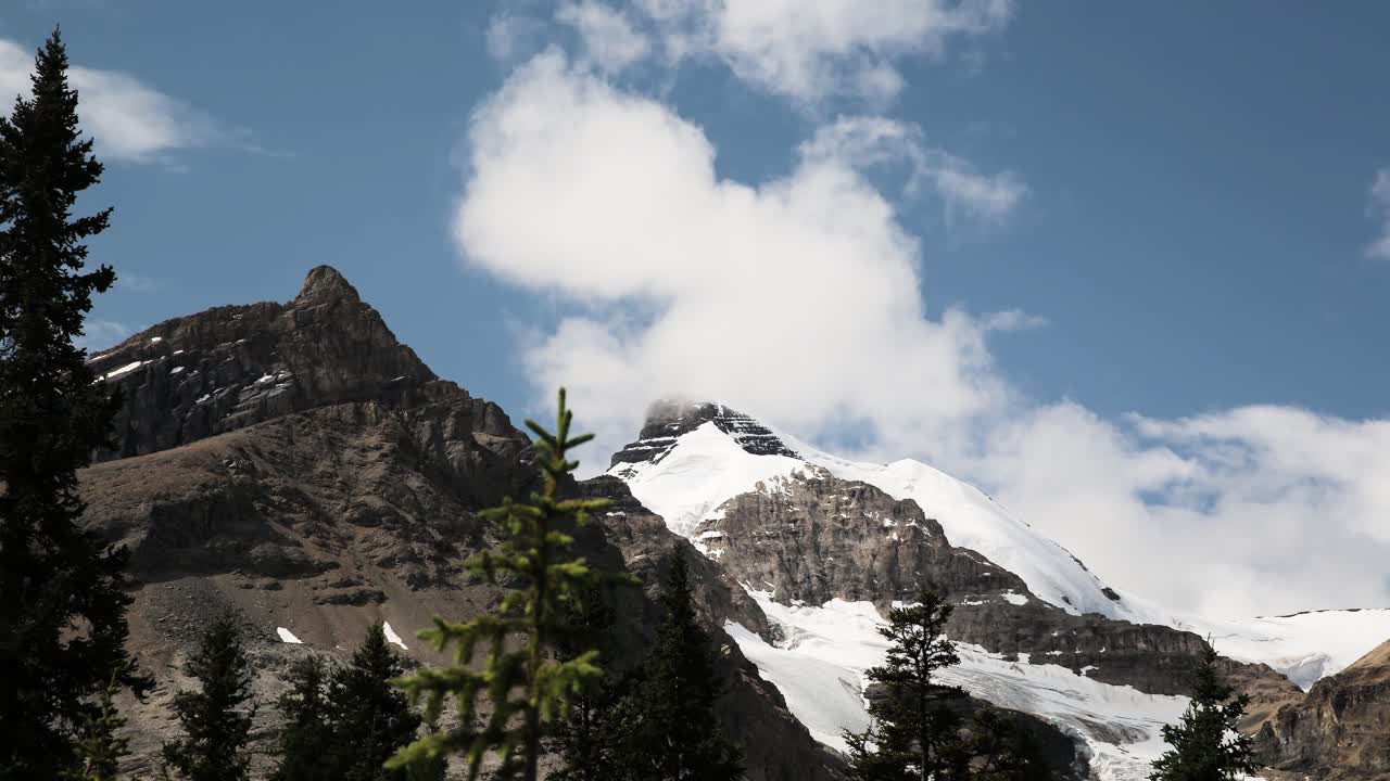 Montagne rocciose alpine, nuvole veloci e foresta di pini. Timelapse