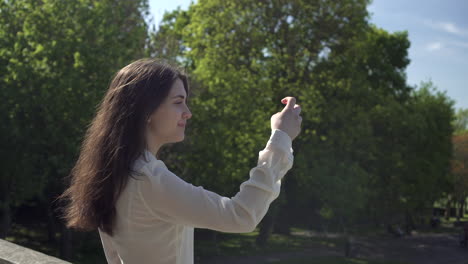 pretty italian woman tourist taking photograph of a park in wimbledon london