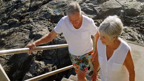 Senior-couple-walking-upstairs-near-beach-4k